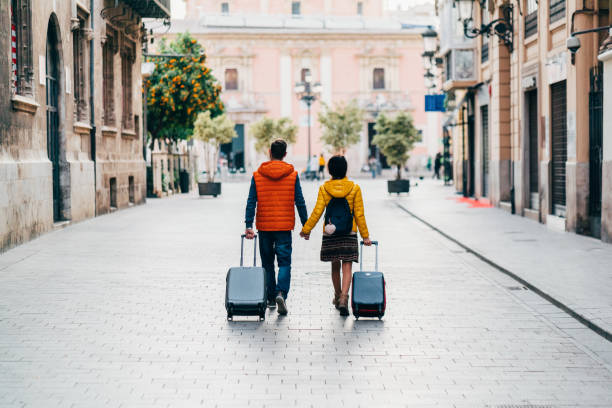 Couple traveling around the world Young couple with suitcases just arriving in Valencia honeymoon stock pictures, royalty-free photos & images