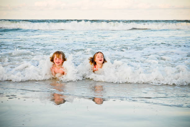 children playing in the waves stock photo