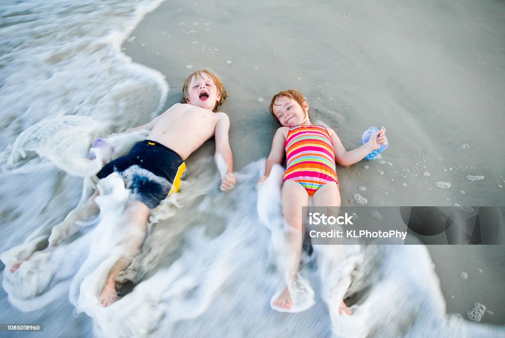 children play in the ocean children play in the waves happy Beach Stock Photo