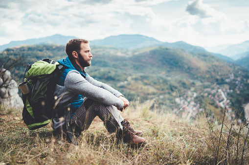 Young man sitting on ground and looking at the view