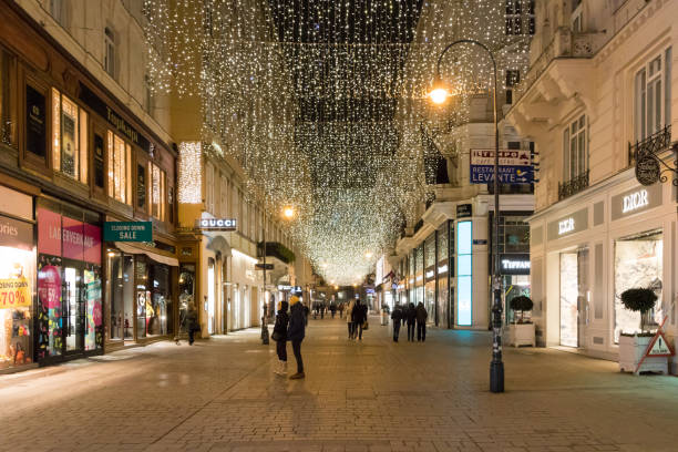 The street Kohlmarkt at night during Christmas Time Evening photo of the shopping street Kohlmarkt with Christmas street light decoration in downtown Vienna. People looking through shop windows. kohlmarkt street photos stock pictures, royalty-free photos & images