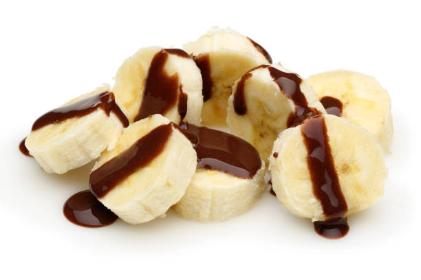 Banana slices topped with chocolate syrup isolated on white background