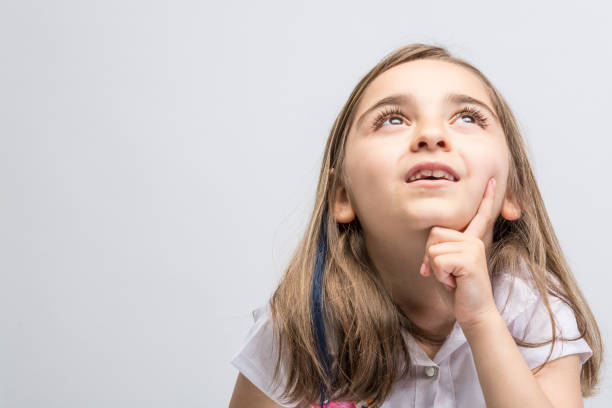 istock Little girl looking up thinking searching for ideas or debating. 1085043240