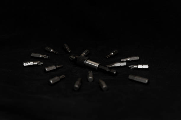 istock Tool carbon steel bits on black background in dark key style. Bit holder in center and bits around bit holder. 1085047870