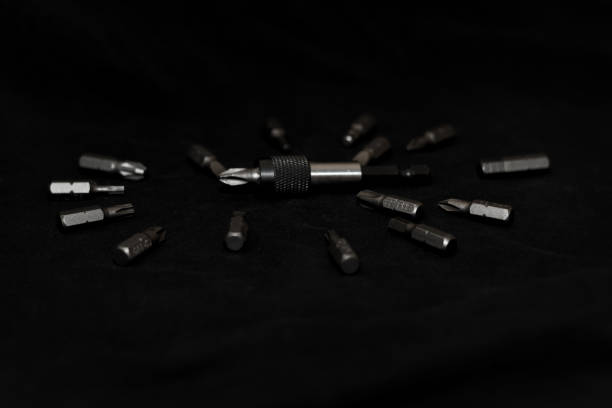 istock Tool carbon steel bits on black background in dark key style. Bit holder in center and bits around bit holder. 1085047876
