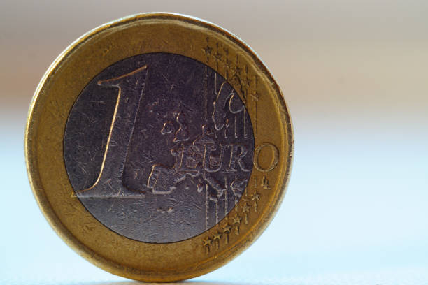 istock Old 1 one euro coin stands on blurred background. 1085048416