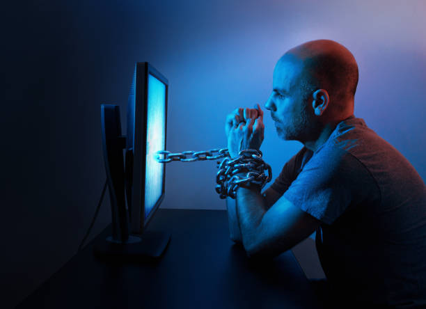 Chained to computer A man is chained to computer late at night. sleaze stock pictures, royalty-free photos & images