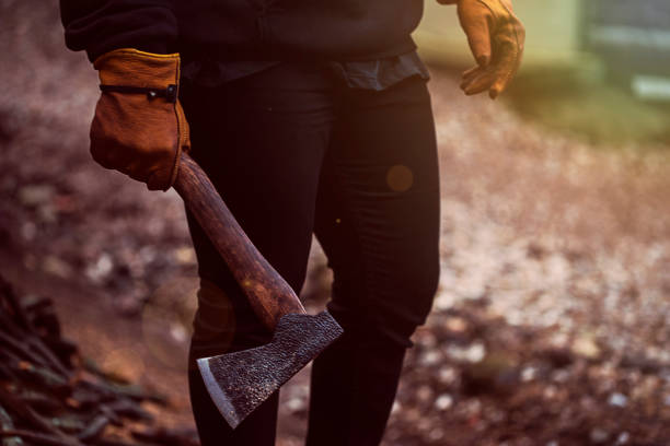 A man holds an axe in his hands against