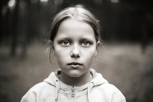 Black and white portrait of tired little girl with sad eyes. Shallow DOF