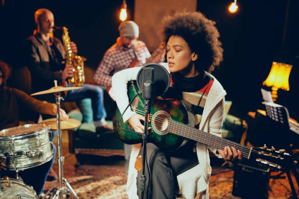 istock Mixed race woman singing and playing guitar. 1085059016