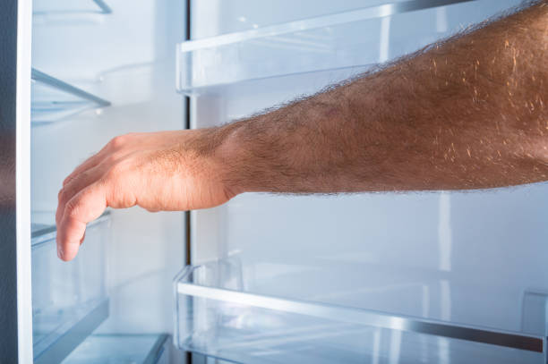istock Man's hand is opening a refrigerator door 1085061054