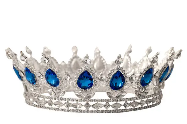 Beauty pageant winner, bride accessory in wedding and royal crown for a queen concept with a silver tiara covered in crystals, diamond and blue sapphire stones isolated on white with clipping path cut out