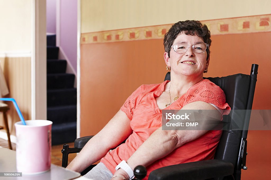 Mulher deficiente em cadeira de rodas a desfrutar de bebida quente em Casa - Royalty-free Cadeira de Rodas Foto de stock