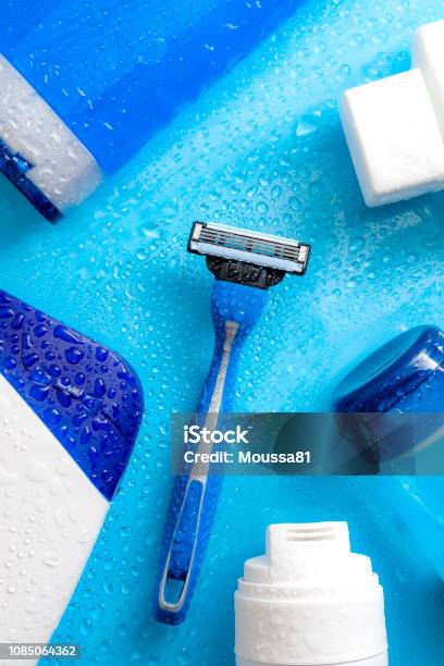 Men Cosmetic Products Personal Hygiene And Male Hair Care And Shaving Concept With Kit Of Masculine Shampoo Aftershave Body Wash Gel And Razor Soaked In Water Droplets On Wet Light Blue Background Stock Photo - Download Image Now