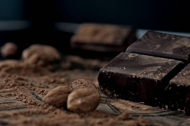 Close-up shot of chocolate pieces and hazelnuts Close-up shot of hazelnuts and chocolate pieces in the background. Selective focus sour taste stock pictures, royalty-free photos & images