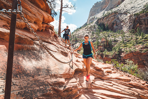 Young Hiker Boy Climbing through the Narrow Path in Fiery Furnace in Arches National Park, Utah, United States.