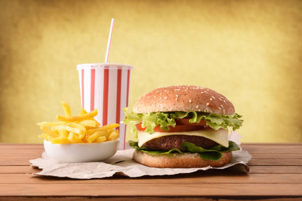 istock Beef burger on table with soda and chips golden backgorund 1085071830