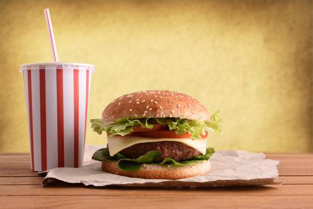 istock Beef burger on wooden table with soda golden backgorund 1085071832
