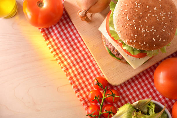 istock Homemade burger on cutting board with ingredients on wood table 1085071866