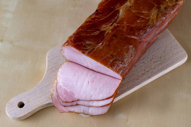 istock Tasty, fresh smoked pork loin on the kitchen table. Tasty meats prepared for home celebration. Light background. 1085073798