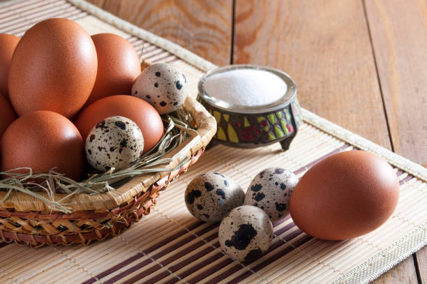 istock Many large brown chicken eggs and small speckled quail eggs on wooden table. 1085076508