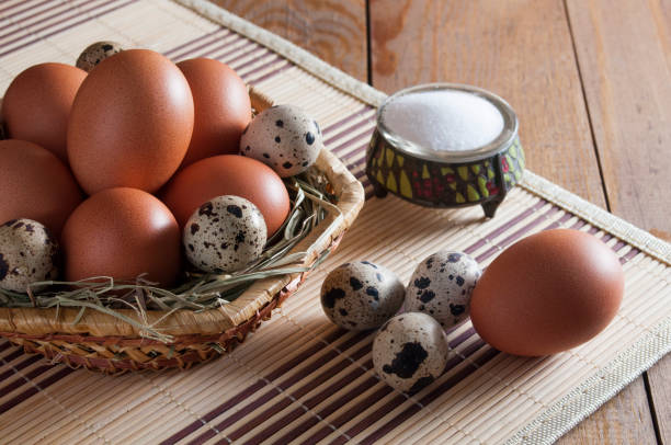 istock Many chicken and quail eggs, salt in salt shaker on wooden table. 1085076686