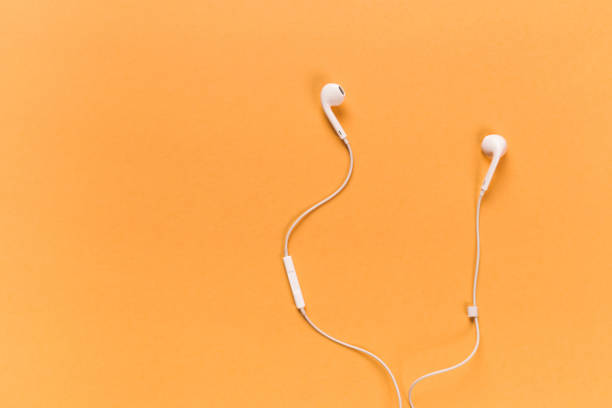 istock White earphones on orange background 1085077476