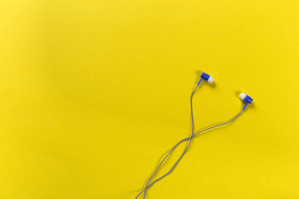 istock black earphones on colour background, top view 1085077492