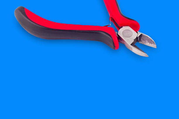 istock Single nippers for wire with red and black handles on blue background with copy space for your text 1085079934