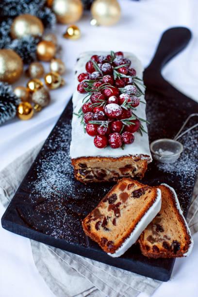istock Christmas stollen with several ingredients on black wooden board decorated with berries and sugar powder. Flat lay. 1085083740