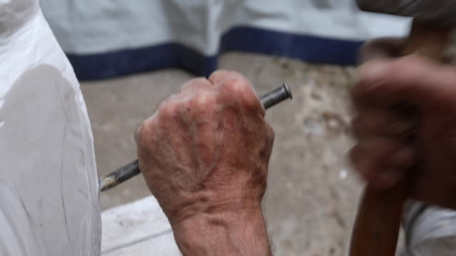 Hands with hammer and chisel