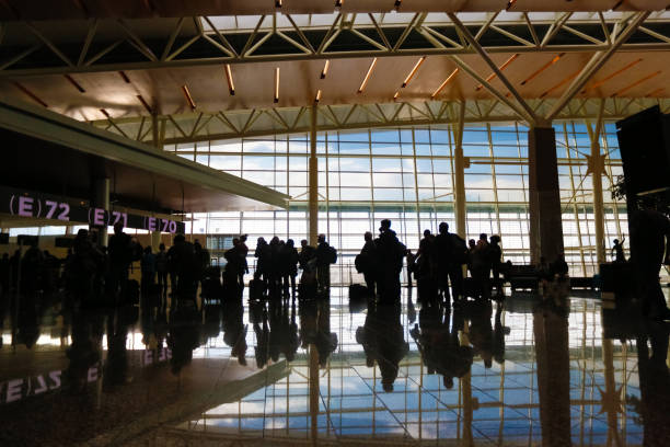 Crowd at Airport Terminal Departures Gate Line of people waiting for their fight at an airport terminal airports canada stock pictures, royalty-free photos & images