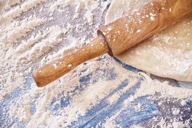 rolled dough lay on a table with a wooden rolling pin