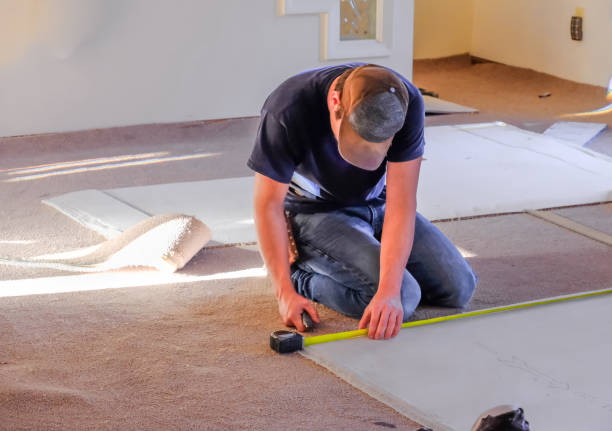 Carpenter measuring new rugs before installation Young man carpenter measuring new rugs he's going to install in house; sunlight coming from the windows carpet stock pictures, royalty-free photos & images