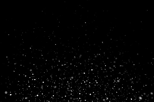 White particles on black background with copy space.