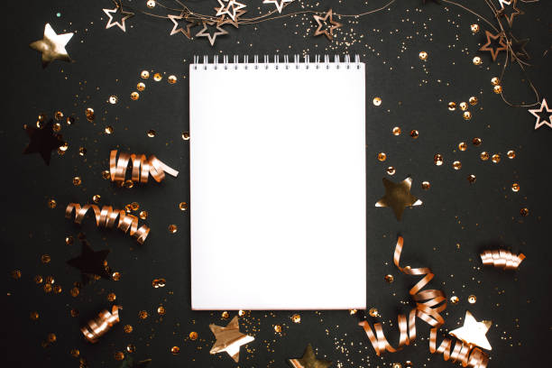 istock Holiday decorations and notebook on black background. flat lay style. 1085103120