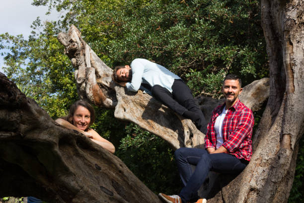 istock Two young men and woman posing on top of tree trunk 1085104486