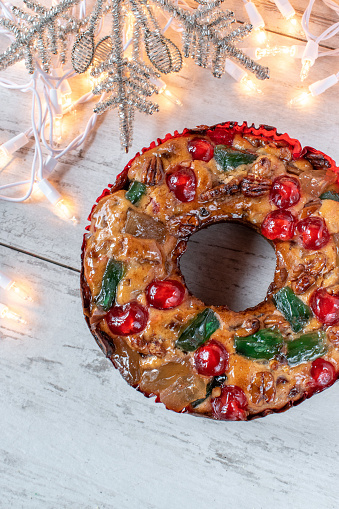 whole fruit cake with Christmas star and lights flat lay