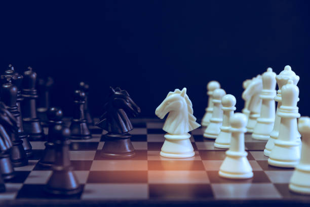 istock The chess board game. A white chess teame and black chess team ,idea for business competition and team work with black blackground 1085114442