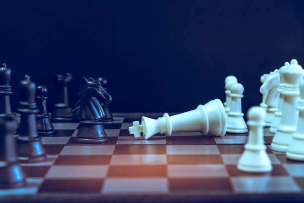 istock The chess board game. A white chess teame and black chess team ,idea for business competition and team work with black blackground 1085114532