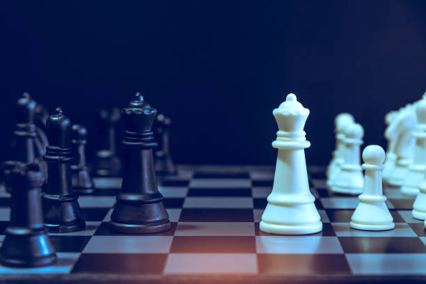 istock The chess board game. A white chess teame and black chess team ,idea for business competition and team work with black blackground 1085114552