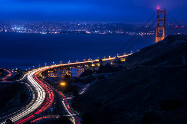 Streaming vehicle traffic headlights and tail lights on the Golden Gate Bridge at dusk. The art deco style Golden Gate Bridge - built in 1937 - connects the city of San Francisco to Marin County, in northern California, USA.