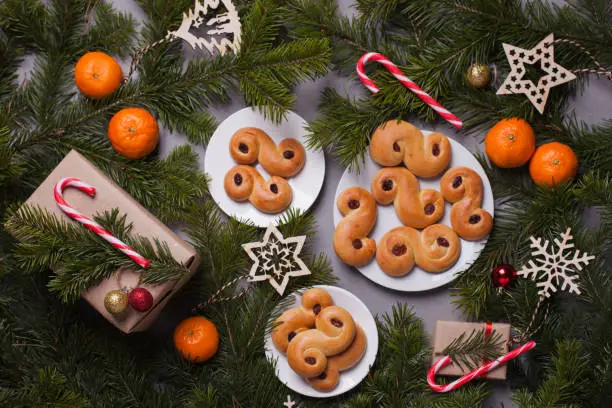 Photo of Traditional Swedish Christmas saffron buns (lussebulle or lussekatt). Swedish christmas. Dark background, Christmas decoration