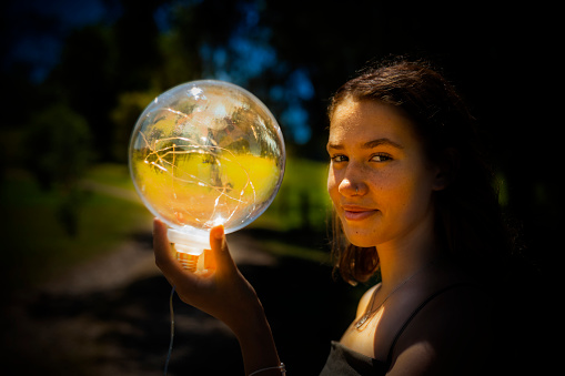 Concept Image With Young Woman With a Glowing Ball of Light
