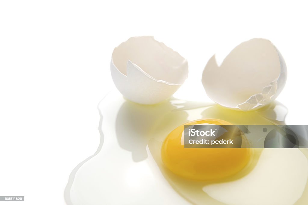 A cracked egg spilt on a white background Egg with sunny side Animal Egg Stock Photo