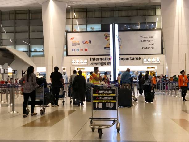 Indira Ghandi International Airport, New Delhi NEW DELHI, INDIA—MARCH 2018: Passengers push luggage carts toward the international departures gates at the Indira Ghandi International Airport in New Delhi. india airport stock pictures, royalty-free photos & images
