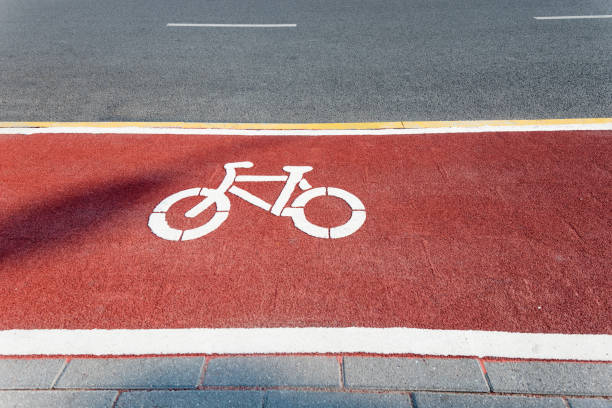 piste cyclable signer sur route rouge - bicycle sign symbol bicycle lane photos et images de collection