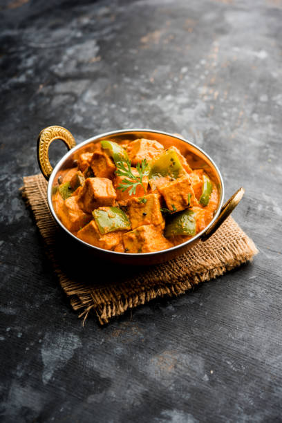 Malai or achari Paneer in a gravy made using red gravy and green capsicum. served in a bowl. selective focus Malai or achari Paneer in a gravy made using red gravy and green capsicum. served in a bowl. selective focus masala stock pictures, royalty-free photos & images