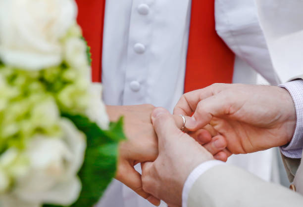 istock Close up groom putting wedding ring into bride's finger 1085160408