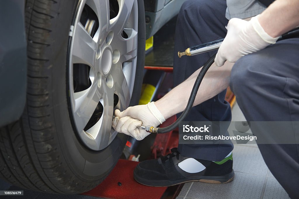 Auto serviço técnico de verificação da pressão de pneu - Foto de stock de Mecânico de Carro royalty-free